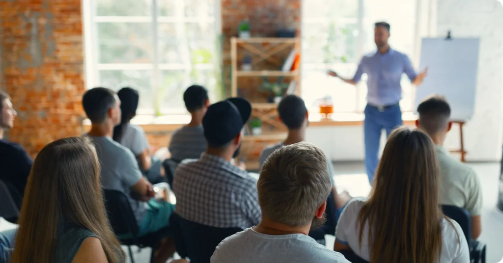 A team at a B2B business watching a presentation by a salesperson.